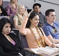 Photo of student raising her hand in lecture hall