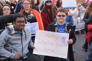 Students holding up a Disability Justice for People of Color sign